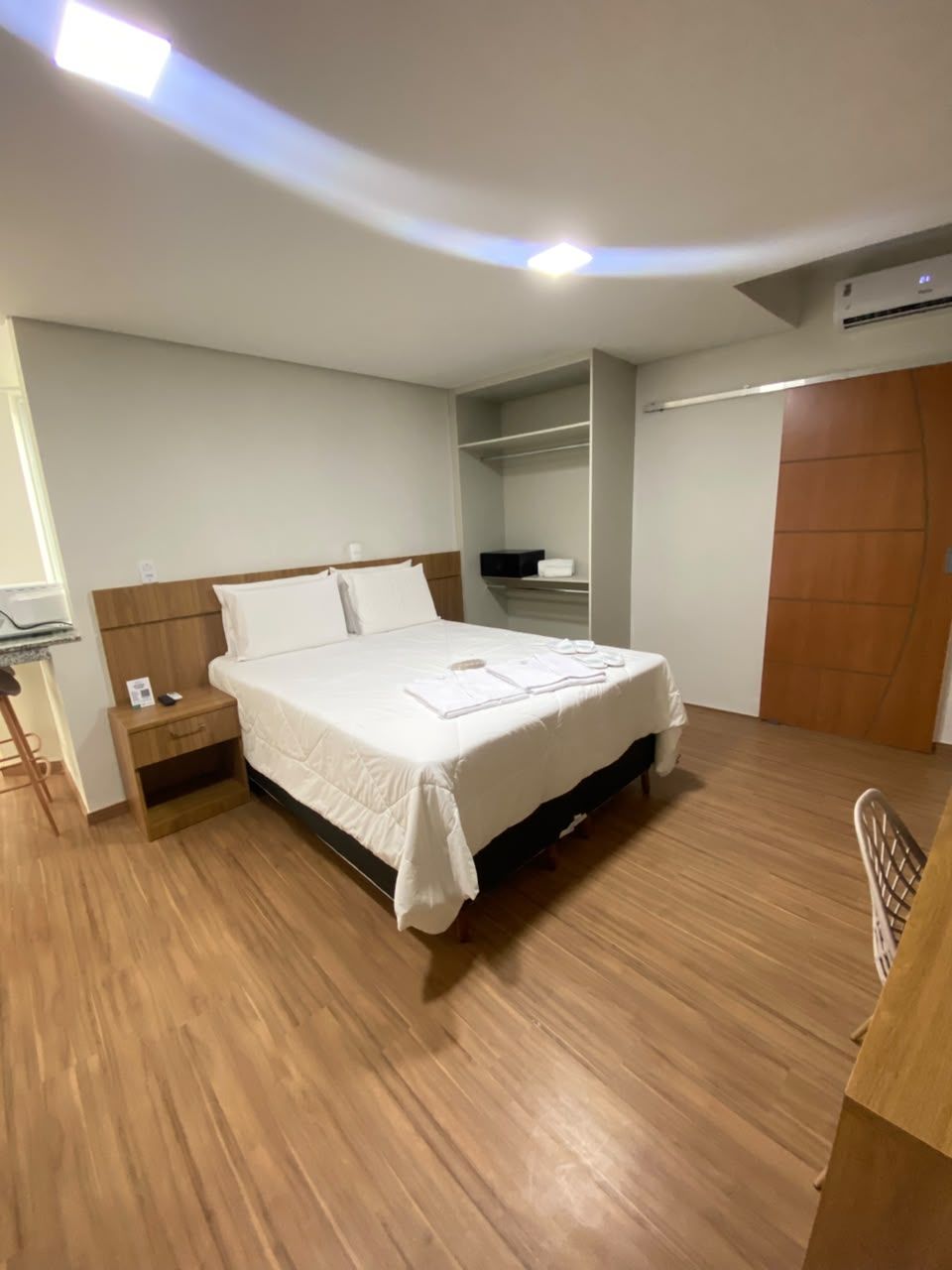 A bedroom with a bed, bedside table, and a wardrobe.