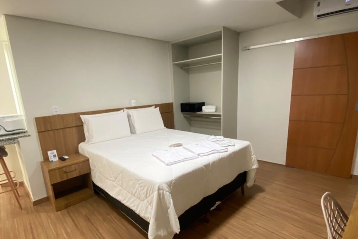 Une chambre à coucher avec un lit, une table de chevet et une armoire.
