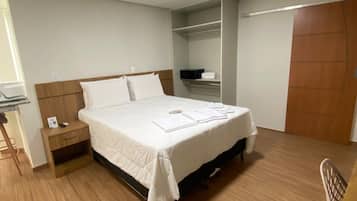 A bedroom with a bed, bedside table, and a wardrobe.