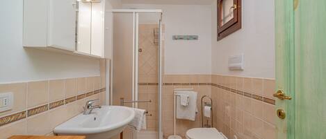 Un baño con lavamanos, inodoro y ducha.