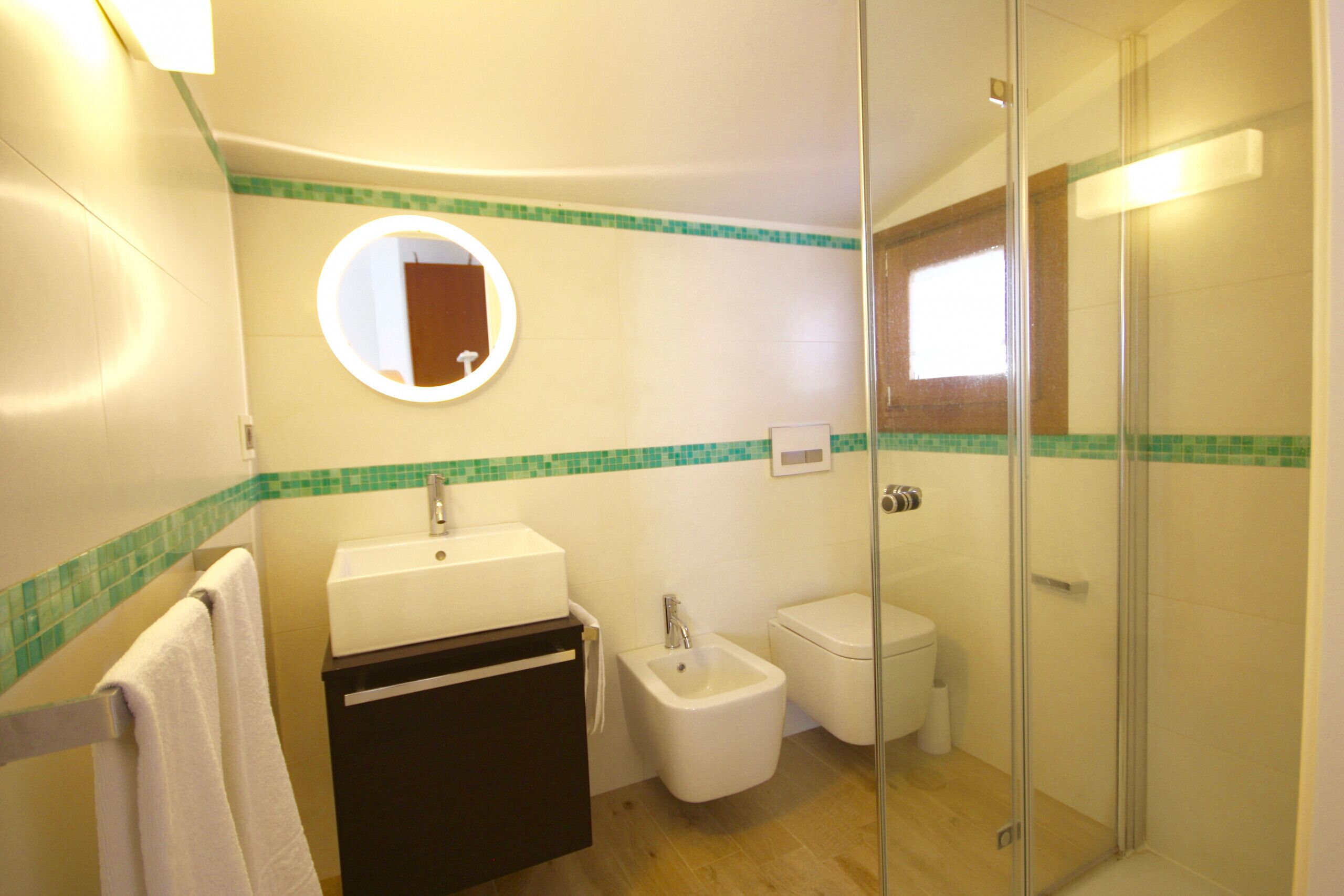 Ein Badezimmer mit Waschbecken, Bidet, Toilette und einer Duschkabine aus Glas.