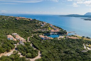 An aerial view of a coastal property with multiple buildings, a marina, and a large body of water. - Casa Pierina by Wonderful Italy (Olbia)