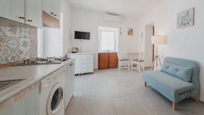 Un espacio habitable compacto con cocina, comedor y sofá.