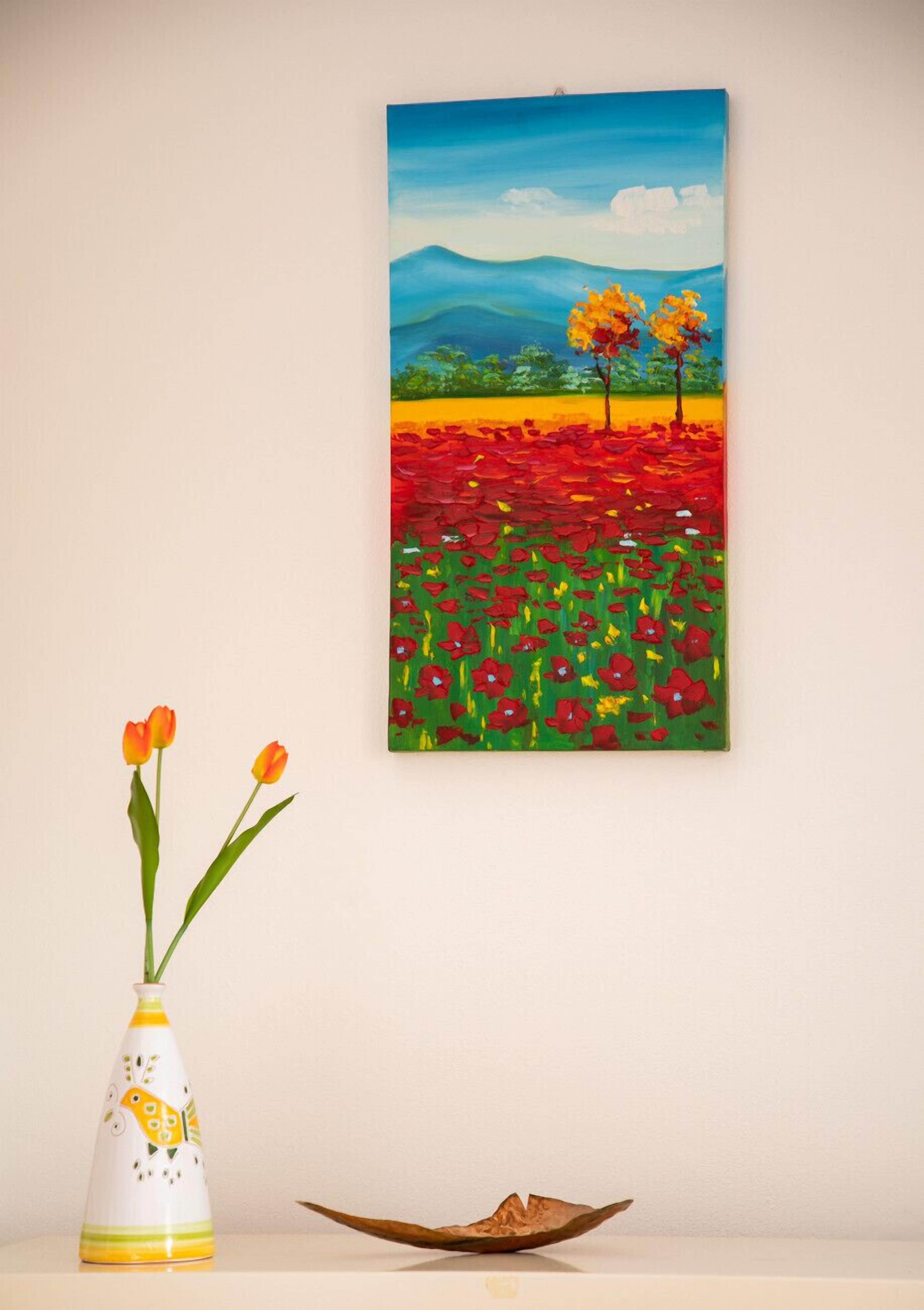 Een schilderij van een landschap met bomen en bloemen aan een muur.