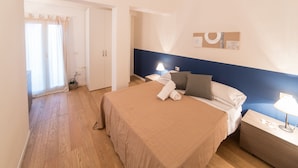 A hotel room with a bed, bedside tables, a lamp, and a window with curtains. - Casa Natal a by Wonderful Italy (Olbia)