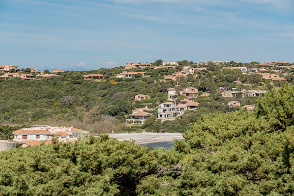 Un quartier résidentiel situé sur une colline, avec des maisons, dont certaines sont dotées de balcons apparents, et entouré de verdure et d’arbres.