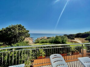 A balcony with a view of the sea, a tree, and potted plants. - Casa Lilly by Wonderful Italy (Arzachena)