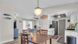 Une cuisine moderne avec un coin repas, un ventilateur de plafond et une enseigne indiquant « Maison de plage ».