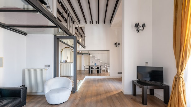 A modern living room with a staircase, a TV, and a dining area. - Appartamento Sammartino by Wonderful Italy (Palermo)