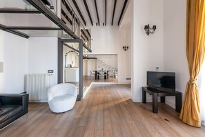 A modern living room with a staircase, a TV, and a dining area. - Appartamento Sammartino by Wonderful Italy (Palermo)