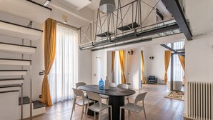 A modern interior with a dining area, staircase, and a view of a living space. - Appartamento Sammartino by Wonderful Italy (Palermo)