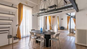 Un interior moderno con comedor, escalera y vista a una sala de estar.
