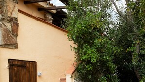 Um edifício de pedra com porta de madeira e escadas que levam a uma área coberta.