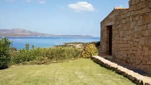 Un edificio de piedra con vistas al mar y a las montañas.