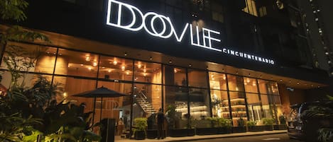A modern building with a large illuminated sign reading "DOVILE CINCUNETENARIO".