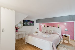 Un dormitorio con cama, mesitas de noche, cómoda, espejo e imagen colgada en la pared.