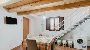 Ein Essbereich mit Tisch, Stühlen, einer Waschmaschine und einer Treppe.