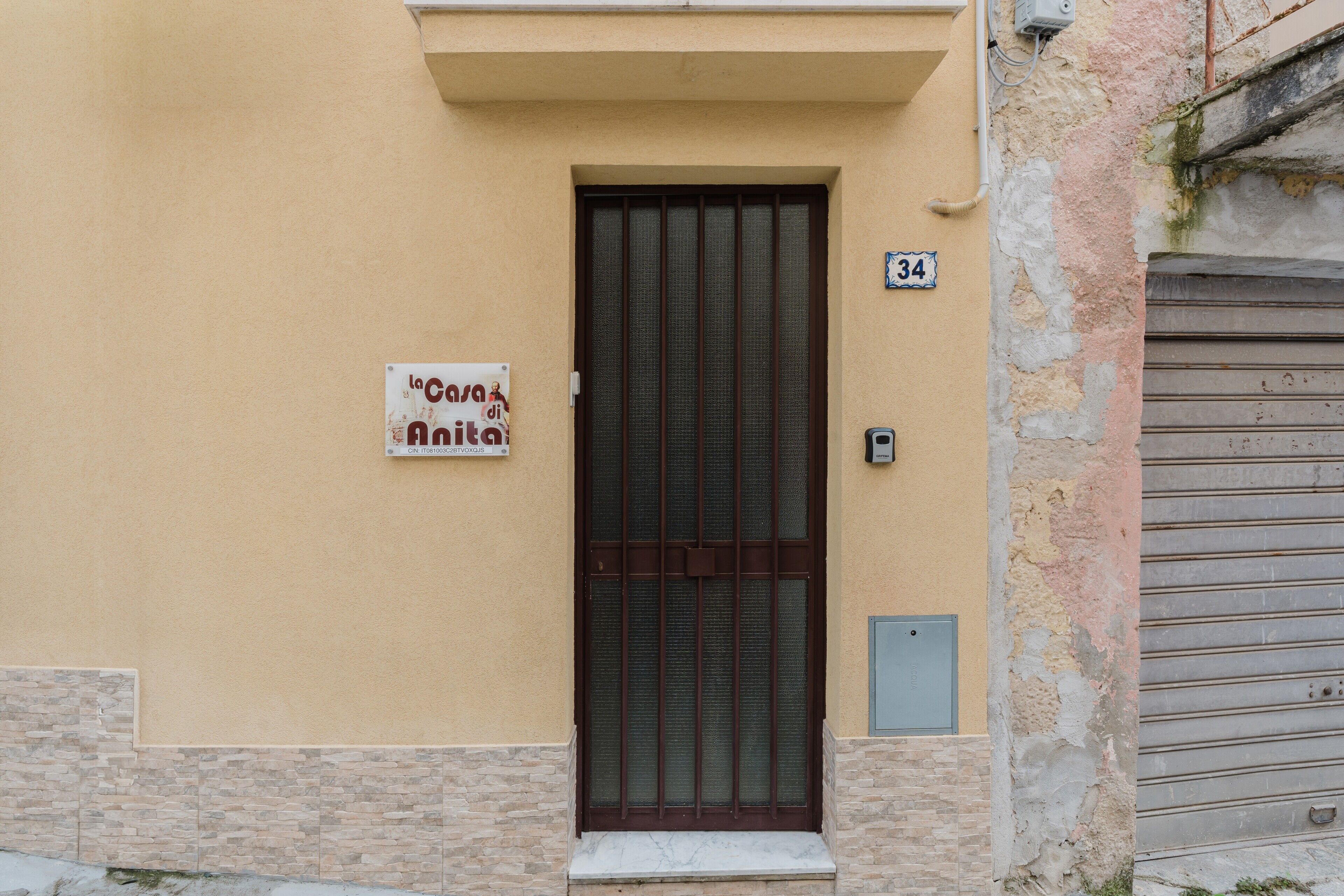 Ein Gebäude mit einer beigen Fassade, einer braunen Tür und einem Schild, das ein Café anzeigt.
