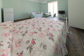 A bedroom with a bed, a desk, a chair, a television, and a refrigerator. - Casa Silvana a Cefal by Wonderful Italy (Cefalù)