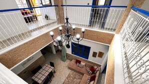 A multi-level living area with a dining table, sofa, and chandelier. - auberge dar fayçal (Mirleft)