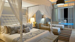 A luxurious bedroom with a four-poster bed, a sitting area with a sofa and armchairs, and a view of a pool. - GRAND LUXXE - THE RESIDENCE FOUR BEDROOM TOWER (Las Jarretaderas)