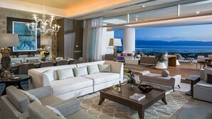 A spacious living area with a large sofa, coffee table, and a view of the ocean. - GRAND LUXXE - THE RESIDENCE FOUR BEDROOM TOWER (Las Jarretaderas)