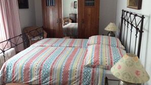 A bedroom with a bed, a wardrobe, a chair, a lamp, and a window. - Apartment 'Cipolla' with Private Terrace, Private Garden and Wi-Fi (Oberkirch)