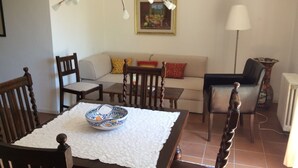 A dining area with a table, chairs, a sofa, and a lamp. - Apartment 'Cipolla' with Private Terrace, Private Garden and Wi-Fi (Oberkirch)