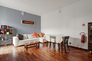 A living room with a sofa, coffee table, and dining table.