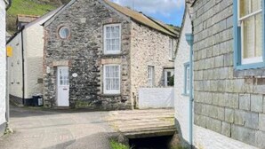 A stone building with a small entrance and a wooden door.