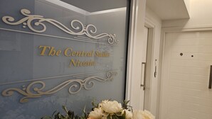 A wall with the text "The Central Suites Nicossia" and decorative swirls. - 116 NIC 302b - Stay Armonia Central Suite (Nicosia)