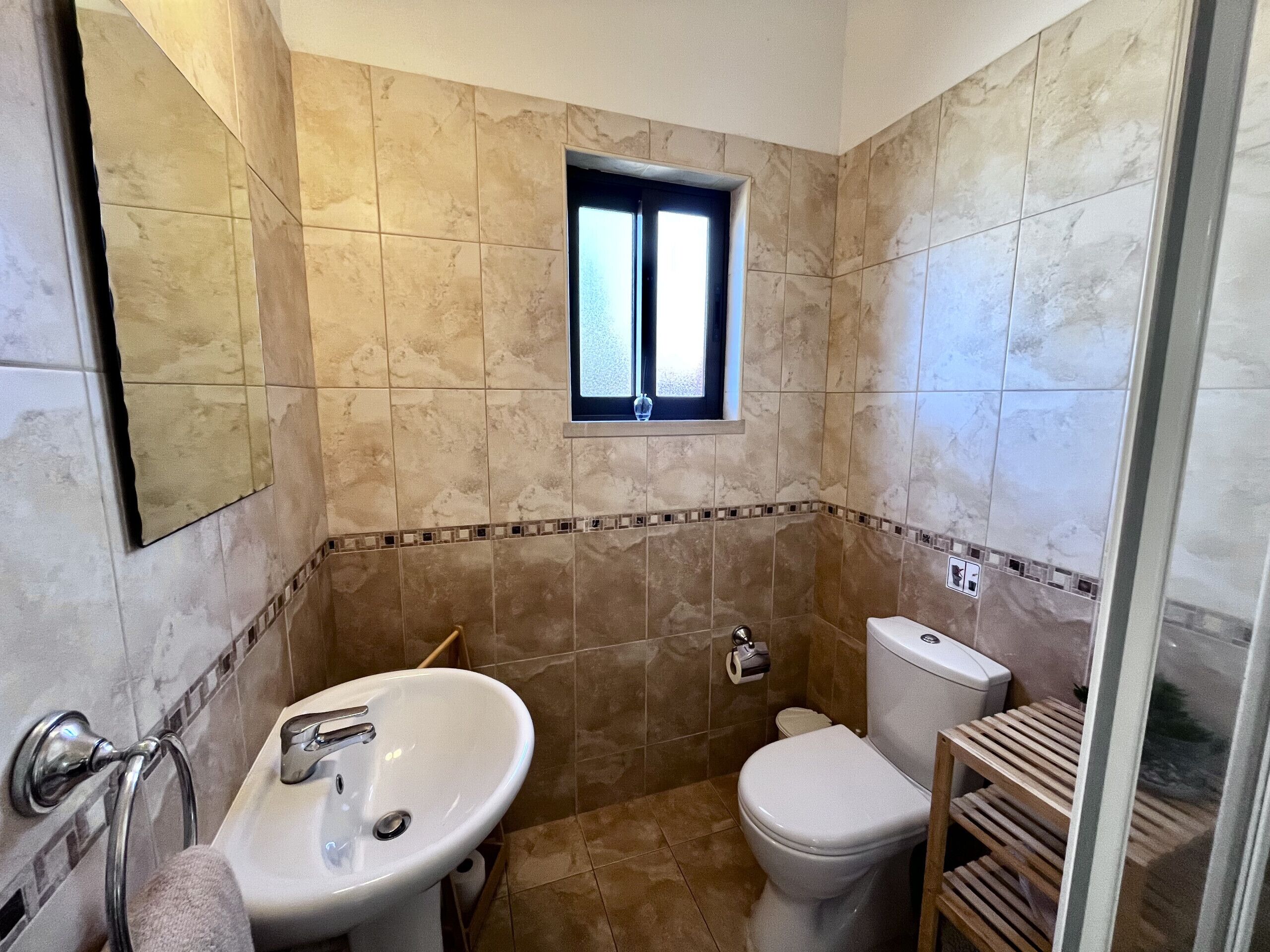 Ein Badezimmer mit Waschbecken, Toilette und Duschbereich.