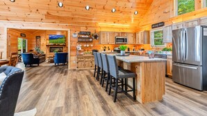A wooden cabin interior with a kitchen, dining area, and living room. - Twin Summit Resort (Sevierville)