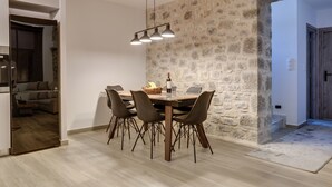 Ein Essbereich mit einer Steinsäule, einem Holztisch und modernen Stühlen.