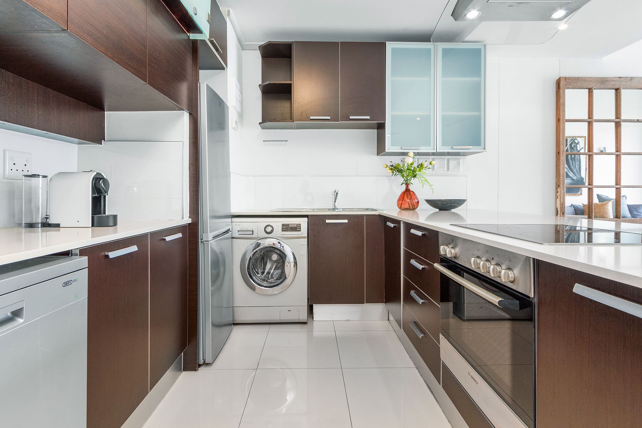 A modern kitchen with stainless steel appliances, wooden cabinets, and a built-in oven.