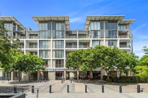 A modern multi-story residential building with balconies, a covered entrance, and a landscaped courtyard. - The Quadrant 406 (Cape Town)