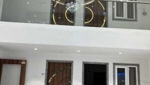 A multi-level building with a glass balcony, large wooden doors, and a modern design. - HOTEL MANGALAM REGENCY (Indore)