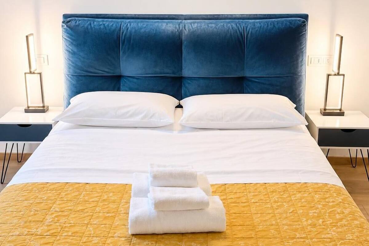 Ein Hotelzimmer mit einem großen Bett, zwei Nachttischen und einem Beistelltisch.