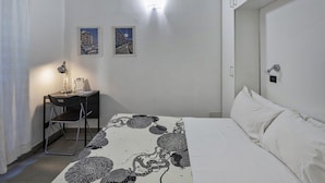 A bedroom with a bed, a desk with a chair, two framed pictures on the wall, and a nightstand. - A Un Passo Dalla Spiaggia di Camogli by Wonderful Italy (Camogli)
