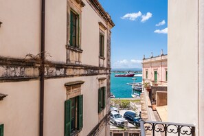 Une vue sur la côte, avec des bâtiments, un quai et un navire rouge.
