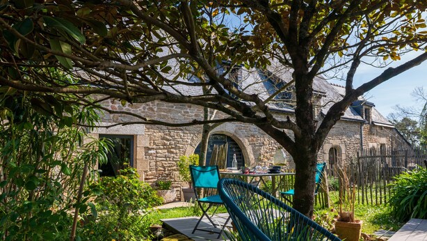 A stone building with a garden patio, a table with chairs, and a hammock. - Voyage B&B with Shared Terrace, Communal Garden & Wi-Fi (Baden)