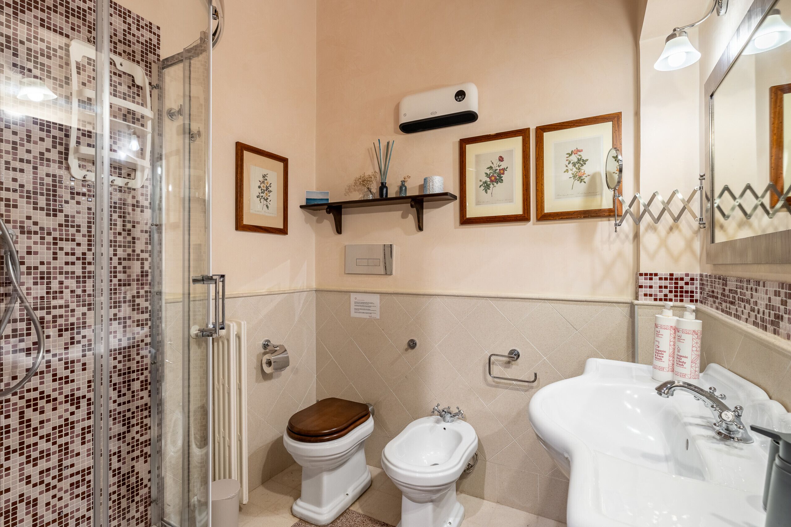 A bathroom with a shower, toilet, bidet, and sink.