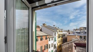 A view through a window of a cityscape with buildings of various colors and architectural styles. - Il Veliero Loft by Wonderful Italy (Genoa)