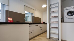 A modern kitchen with a built-in oven, a microwave, and a washing machine. - Il Veliero Loft by Wonderful Italy (Genoa)
