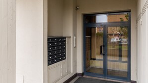 A building entrance with a glass door, a mail slot, and a tiled floor. - Casa Berti by Wonderful Italy (Bologna)