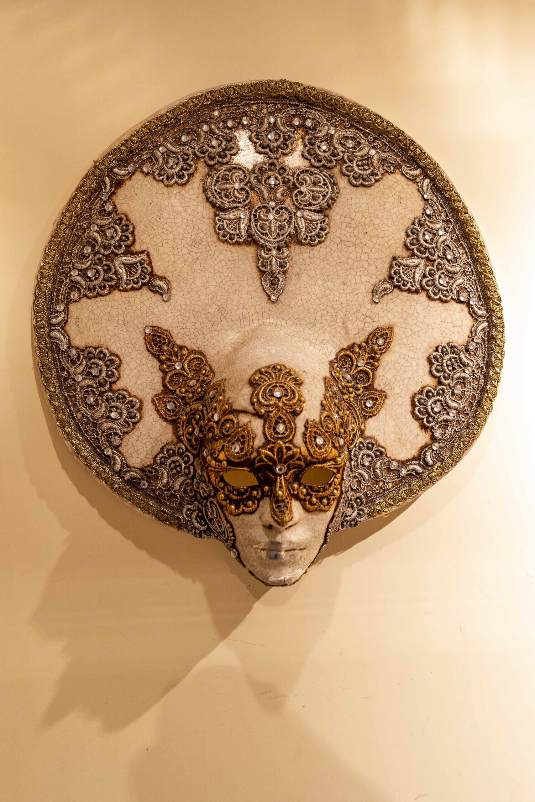 Uma peça decorativa de parede com padrões elaborados e uma figura central.