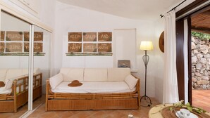 A room with a sofa, a lamp, and motivational wall art. - Casa del Bonsai by Wonderful Italy (Arzachena)