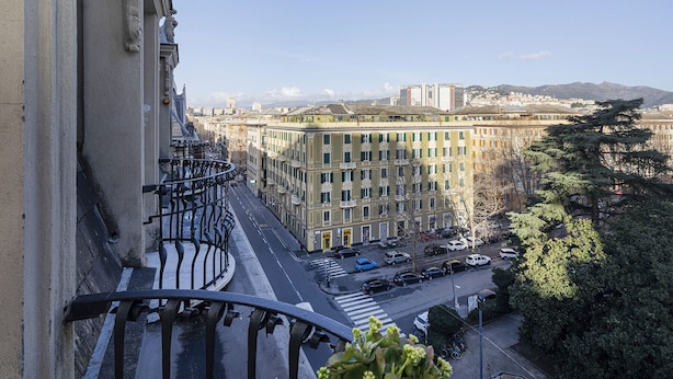 Un paisaje urbano con un edificio que tiene balcones y una calle abajo.