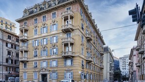 Un edificio de varios pisos con detalles arquitectónicos ornamentales, incluyendo balcones y molduras decorativas.
