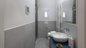 Un baño pequeño con un lavamanos blanco, una toalla y un espejo.